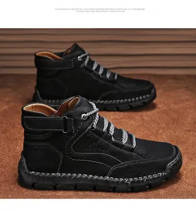 Detail view of black leather men's work boots with white stitching and non-slip rubber soles