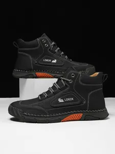 Detailed close-up of high-top leather boots featuring white stitching and orange accents