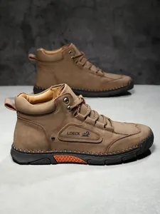 Detailed close-up of brown suede leather work boot with contrast stitching and rubber sole