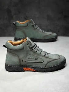 Detailed view of green leather boots with hand-stitched soles and orange non-slip grip