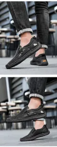 Detail von schwarzen Herren-Slippern aus Narbenleder mit seitlichem Reißverschluss und Logo