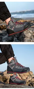 Primer plano de botas de cuero para senderismo con cordones rojos en terreno rocoso
