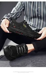 Close-up of handmade stitching details and side print on black leather loafers for men