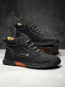 Detail of hand-stitched seams on black leather Martin boots with orange sole accents