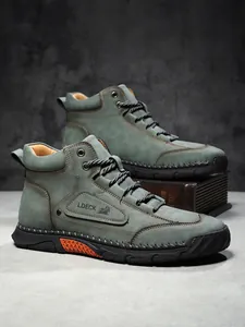 Detail of olive green nubuck leather boot featuring hand-stitched seams and orange accents