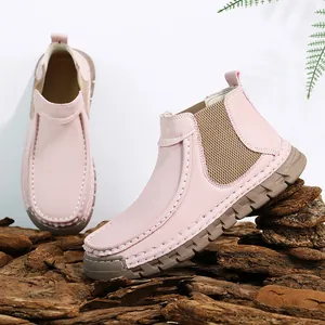 Detail van roze leren enkellaarsjes met elastische zijkant en stiksels op dikke zool