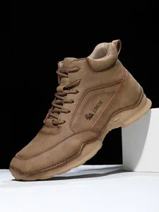 Détail de la botte en cuir PU marron pour homme avec logo latéral et coutures faites main
