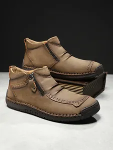 Detail of men's leather boots showing handmade stitching and 100% rubber sole
