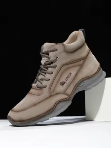 Détail de bottines en similicuir pour hommes avec logo latéral et semelles antidérapantes