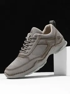 Nahaufnahme grauer Wildleder-Loafer mit seitlichen Perforationen und Gummisohlen