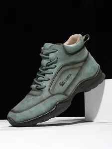 Gros plan de bottines en cuir vert gris mat pour hommes avec semelle en caoutchouc