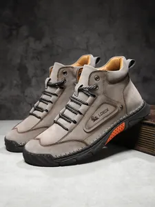 Macro detail of high-top leather boots showing industrial stitching and logo branding