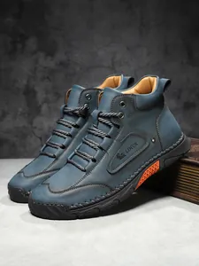 Detail view of navy blue leather work boots with visible stitching and LDECK logo
