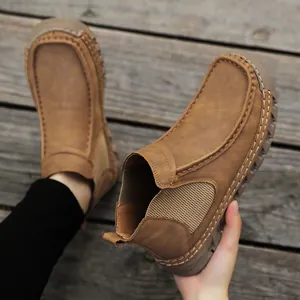 Detail van handgestikte naden en bruin suède leer op casual Chelsea slip-on schoenen
