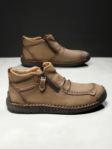 Close-up of brown leather boots showing metal zipper and 100% rubber sole detail
