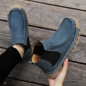 Detail van handgestikte naden en marineblauw suède op casual instapschoenen voor