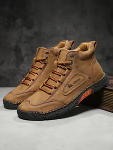 Close-up of brown leather men boot showing side logo, stitching and textured rubber sole