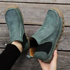 Detail van blauwgroene suède instappers met contrasterende stiksels en rubberen zool