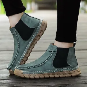 Zijaanzicht van handgemaakte blauwe suède loafers met contraststiksel en rubberen zolen