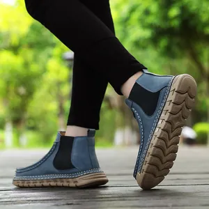 Detail van blauwe loafers met duurzame rubberen zolen en handgemaakte contraststiksels