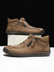 Detail of brown leather men's boot showing side zipper and contrast hand-stitched seams