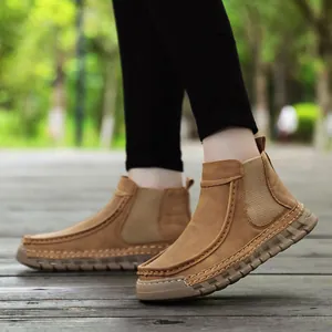 Detailopname van bruine suède Chelsea-boots met handgestikte naden en dikke rubberen zool