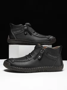 Close-up of black pebble leather boots with side zipper and contrast hand-stitched detailing