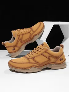 Detailansicht der braunen Wildleder-Loafer mit Ziegen-Logo und atmungsaktiver Nahtstruktur
