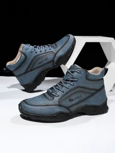 Vue détaillée des bottes en cuir PU bleu avec coutures renforcées et semelles en caoutchouc