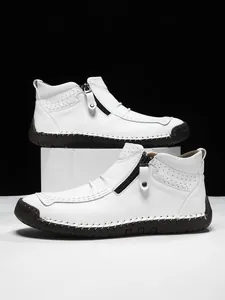 Close-up of white pebble leather high-top shoes with zipper and moc-toe hand stitching