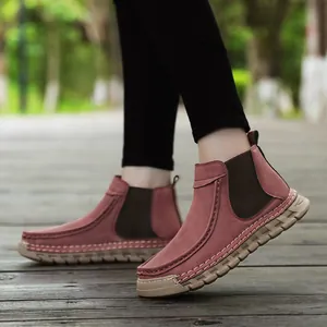 Detail van roodbruine suède damesloafers met handgemaakte naad en dikke rubberen zool