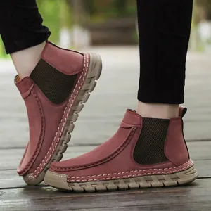 Detail van handgenaaide casual loafers in rood suède met antislip dikke zolen