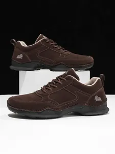 Detail von dunkelbraunen Wildlederschuhen mit Ziernähten und rutschfester Gummisohle