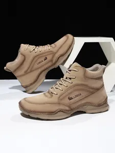 Détail de bottines en daim kaki avec coutures faites main et semelles en caoutchouc durables