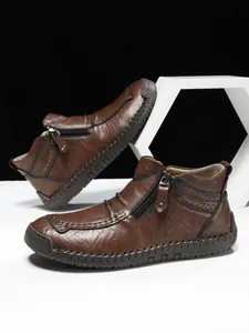 Detail of men's leather boots with hand-stitched seams and side zipper closure