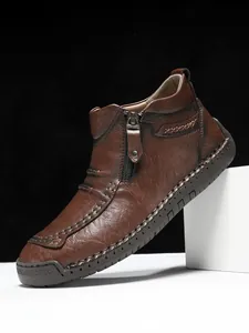 Detail of brown leather men boot featuring side zipper and thick handmade stitching
