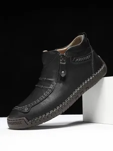 Detail of black leather boots showing lychee texture, side zipper and handcrafted stitching