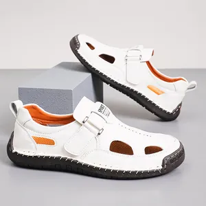 Detalle de sandalias de cuero blanco con forro naranja y correas de velcro seguras