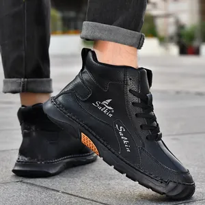 Détail de bottines décontractées en cuir noir avec texture litchi et pièce décorative orange