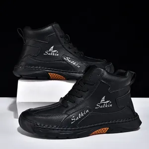 Détail de bottines en cuir noir avec logo latéral et semelle en caoutchouc orange