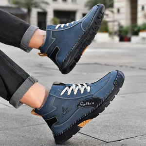 Détail de bottines outdoor en daim bleu avec broderie Salkin et semelle en caoutchouc