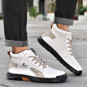 Détail de baskets mi-hautes blanches avec empiècements en daim beige et semelles noires