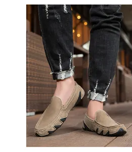 Détail de mocassins en daim kaki avec coutures main et semelle en caoutchouc dentelée