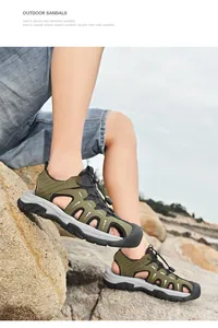 Nahaufnahme der militärgrünen Leder-Sportsandalen auf Felsen zum Wandern im Freien