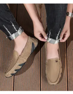 Gros plan d'un mocassin en cuir nubuck kaki avec semelle antidérapante sur fond de bois