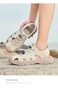 Detail von geschlossenen Leder-Sandalen für Herren mit Gummizug auf Küstenfelsen