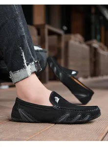 Détail des mocassins en daim noir avec broderie de chèvre blanche et semelle vague