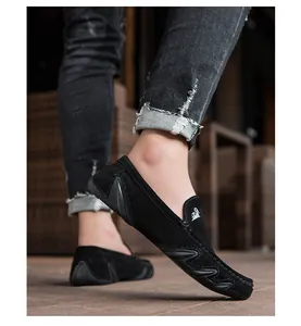 Détail de mocassins en daim noir montrant les renforts latéraux et la semelle antidérapante