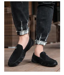 Gros plan de mocassins en daim noir avec détails cousus main et semelle en caoutchouc