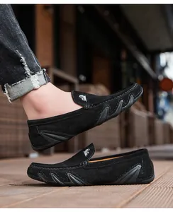 Gros plan de mocassins en daim noir avec logo blanc et semelle en caoutchouc ondulée